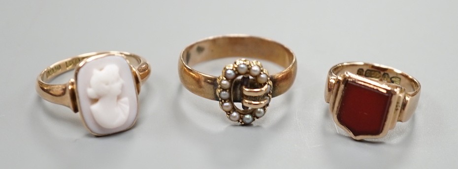 A late Victorian 9ct gold and carnelian set signet ring, size G and tow later 9ct rings including seed pearl buckle and cameo, gross weight 10 grams.